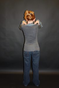 child stood straight with hands resting on their shoulders, back image 