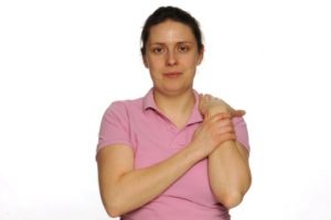 Photograph of person holding wrist up to the shoulder
