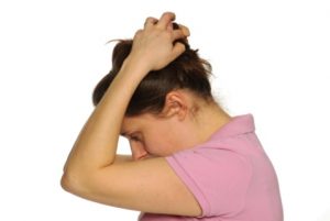 Photograph of person with their hands clasped behind their head to push their head down so their chin is going towards their chest