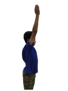 Child standing with their arm pointing straight up