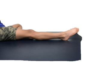 Photograph of person laid on their back with one leg outstretched and point their toes away from themselves