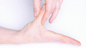 Photograph of person's hand resting on a table with their fingers straight and thumb outstretched to the side and using their other hand to pull at their thumb