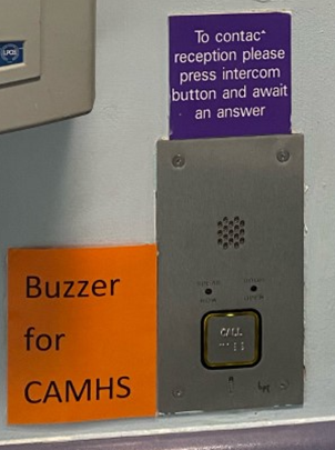Photograph of buzzer and orange sign saying 'Buzzer for CAMHS' next to it
